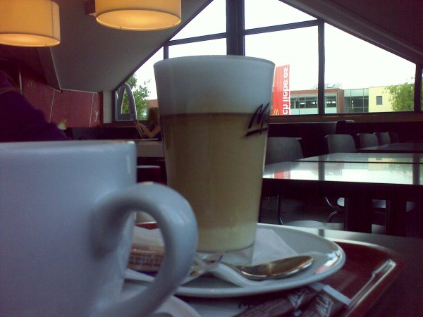Ein Glas Latte Macchiato und eine Kaffeetasse von McCafé